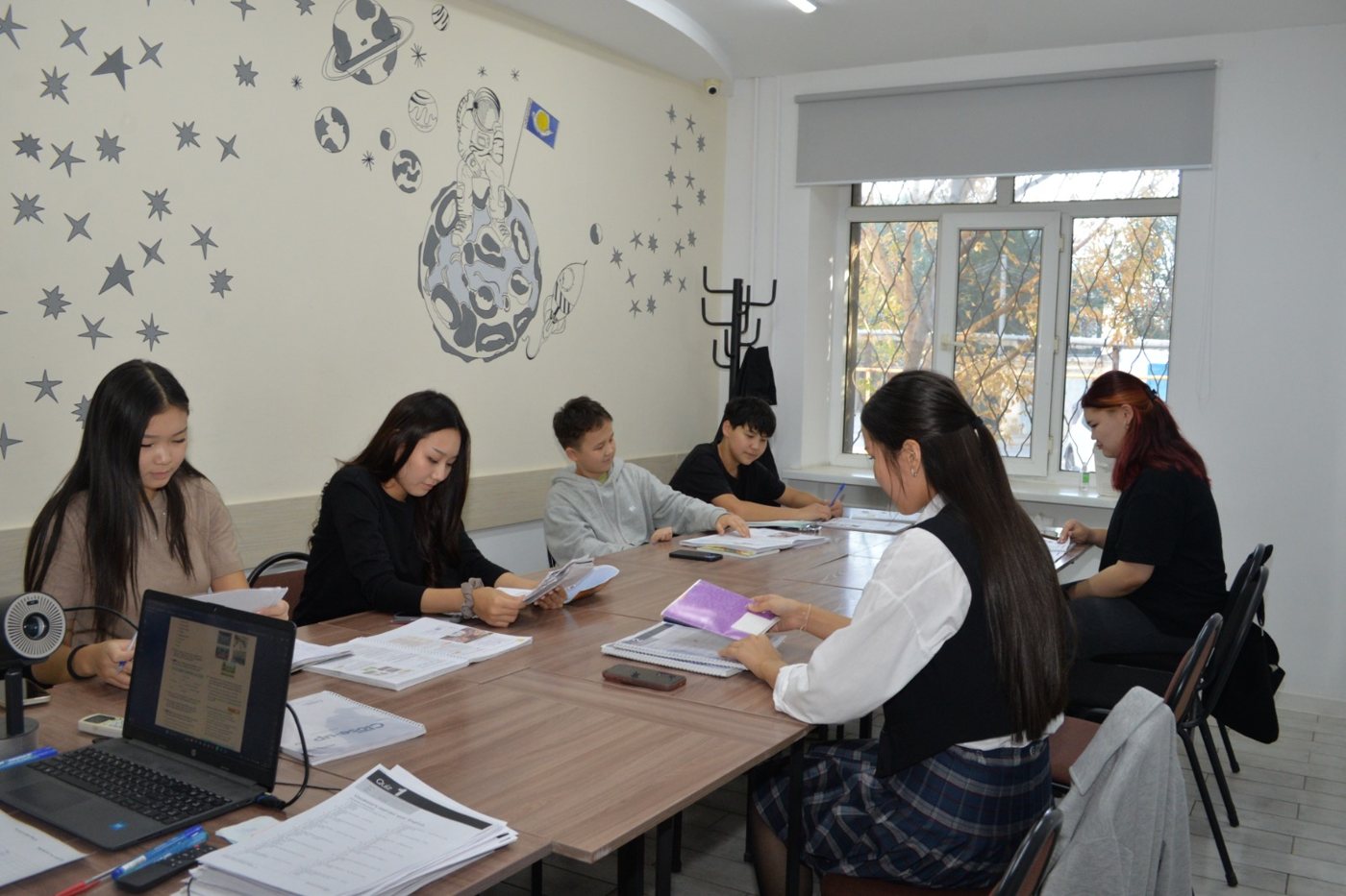 Занятие в Caspian Training Group в Атырау: студенты за столом с учебниками